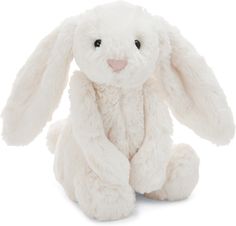 a white stuffed rabbit sitting up against a white background