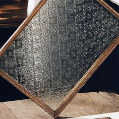 a wooden table topped with a mirror on top of it's side next to a window