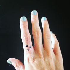 a woman's hand with a small star tattoo on her left ring and the other half of her finger