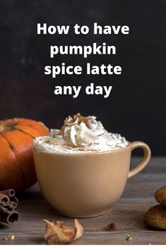 a pumpkin spice latte with whipped cream in a mug next to some cinnamons