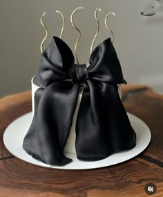 two black bows on top of a white cake