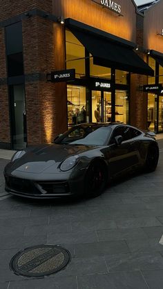 a black sports car parked in front of a store