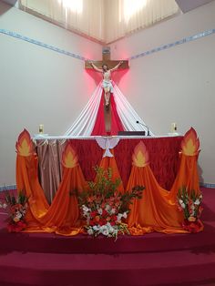 the altar is decorated with flowers, candles and a crucifix