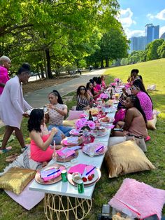 a group of people sitting at a picnic table eating cake and drinking watermelon