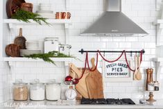 a kitchen with white cabinets and shelves filled with cooking utensils, cutting boards and other items