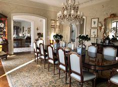 a formal dining room with chandelier and chairs