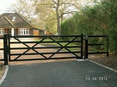 a gated driveway leading to a house