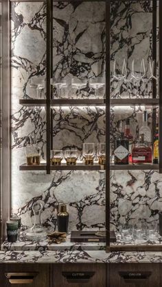 a marble bar with wine glasses and liquor bottles