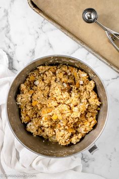 a metal bowl filled with food on top of a white counter