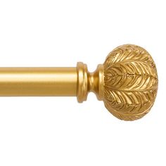 a gold curtain rod with an ornate design on it's end and a leafy finial