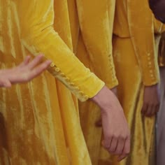 several people in yellow robes are standing together and one person is holding the other's hand