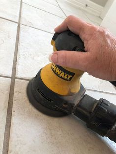 a person using a power tool on a tile floor