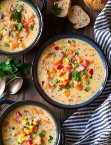 four bowls of soup with bread on the side