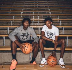 two young men sitting on bleachers holding basketballs