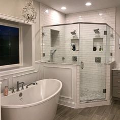 a large white bath tub sitting next to a walk in shower