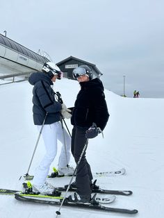 two people standing on skis in the snow