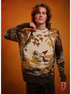 a young man is posing for the camera wearing a sweater with an image on it