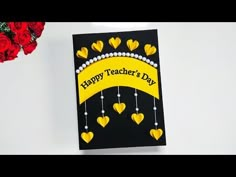 a card that says happy teacher's day with hearts hanging from it