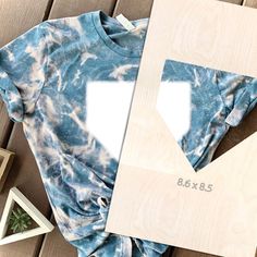 a blue tie - dye t - shirt with two white square cutouts on it