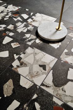 an umbrella is sitting on the ground in front of some broken tiles and flooring