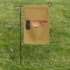 a small flag is in the grass on a sunny day, with an image of a camper's wing