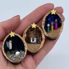 three miniature nativity ornaments in the palm of someone's hand