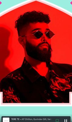 a man wearing sunglasses and a black shirt is looking off to the side in front of a red background