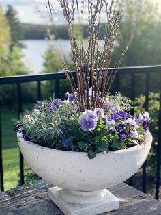 a large white bowl filled with lots of purple flowers