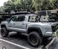 a gray truck parked in a parking lot next to other vehicles and trees with the words trd 4x4 written on it