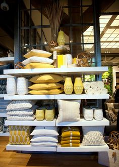 the shelves are filled with yellow and white pillows