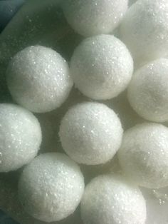 some white balls are in a bowl on the counter top, and it looks like they have been coated with sugar