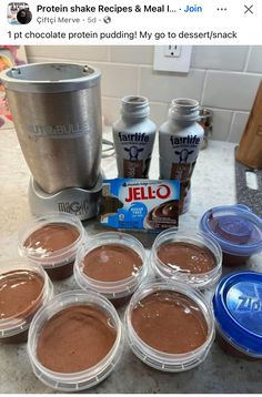 chocolate pudding in plastic containers next to an ice cream maker