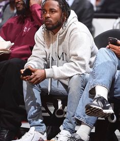 two men sitting next to each other at a basketball game