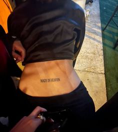 a woman with a small tattoo on her lower back that says made in heaven,