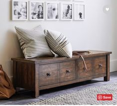 a wooden bench with pillows on it in front of pictures and a handbag sitting next to it