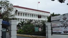 a large white building with a flag on the top of it's roof and gate