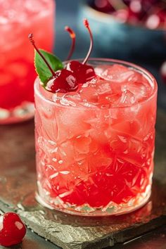 two glasses filled with ice and cherries