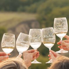 people holding wine glasses with names on them