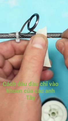 two hands are holding scissors and threading together