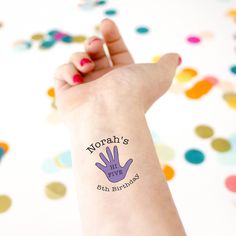 a woman's arm with a purple hand tattoo on it