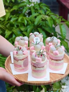 small desserts are arranged on a wooden tray in the shape of hearts and flowers