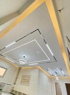 a room with white walls and gold trimmings on the ceiling is lit by recessed lights