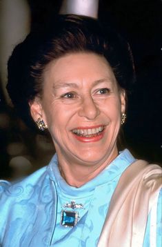 an older woman in a blue dress smiling