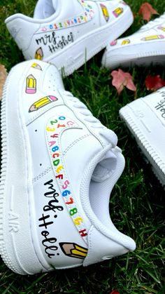 white sneakers with colorful writing on them sitting in the grass