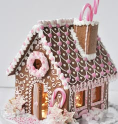 a gingerbread house decorated with pink and white icing