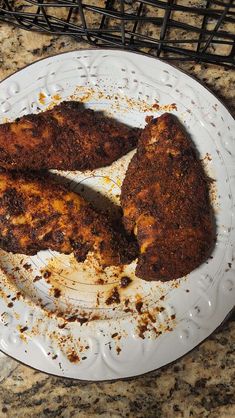 two pieces of fried chicken on a white plate