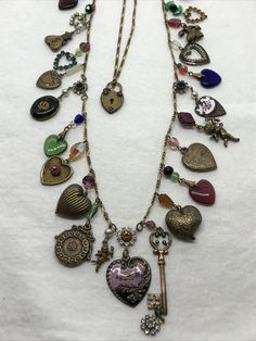 Vintage  Glass Works Studios                                      (13) Brass tone Chain & Charms Necklace   necklace features many charms, glass crystals, faux pearls and enamel work in a floral and heart theme center piece design. Necklace overall chain length is apx 33" **small crystal missing from one flower-see picture** Please see all photos for measurements and visual details. Item is new / never worn stock from jewelry store that closed in 2002 Item is described to the best of my ability, items may have tarnish / patina from storage. Any props used in photos are not included unless stated otherwise. I will gladly combine shipping for more than 1 item when possible but must let us know before sending payment. Please visit my ebay store for other items that will be added frequently. Vintage Charm Necklace, Thrifting Manifestation, Domino Necklace, Vintage Assemblage Necklace, Vintage Assemblage Jewelry, Found Object Jewelry, Heart Theme, Multi Coloured Necklaces, Vintage Assemblage