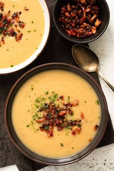 two bowls filled with soup sitting on top of a table