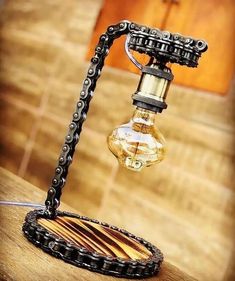 an old fashioned light bulb sitting on top of a wooden table next to a chain