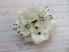 a white flower with black beads and pearls